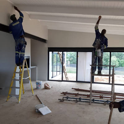 Skhosana Projects team members painting and renovating the interior of a home